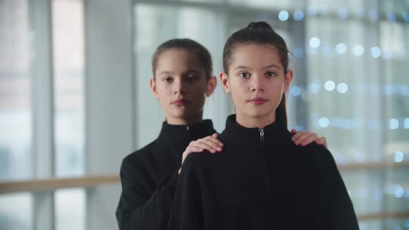 Little Girl Twins Standing in the Studio and Synchronously Looks Up