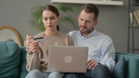 Couple Having Online Shopping Failure on Laptop on Sofa