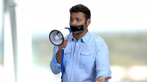 Expressive Man with Taped Mouth Trying To Speak