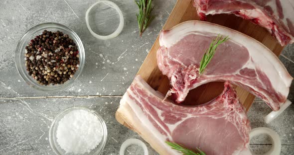 Raw Pork Escalope with Rosemary and Onions on the Table. 