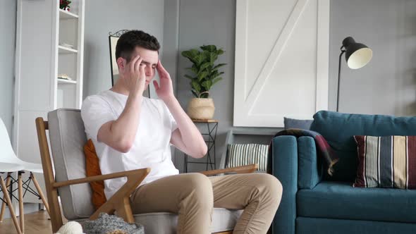 Man Sitting on Couch with Headache Pain and Problems