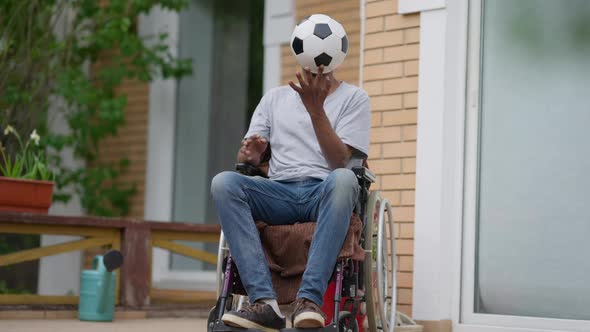 Portrait of Paraplegic African American Sportsman Spinning Ball on Finger in Slow Motion Thinking