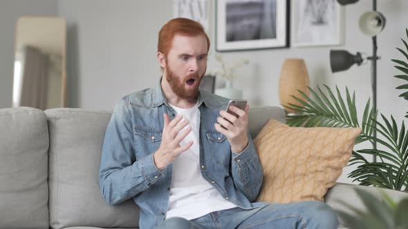 Astonished Man Shocked By Result on Smartphone, Wondering