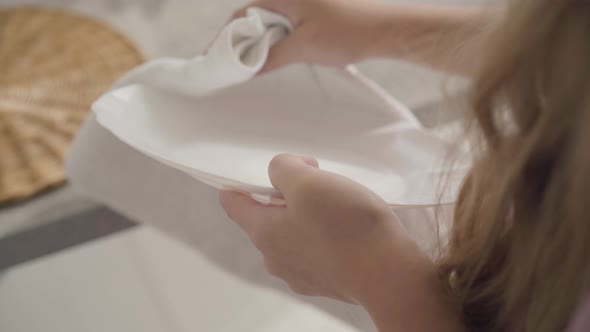 Close-up of Teenage Caucasian Female Hands Wiping Plates with Soft White Cloth, Diligent Girl Doing