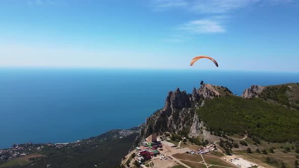A Paraglider Flies on a Paraglider Against the Backdrop of the Beautiful Peaks