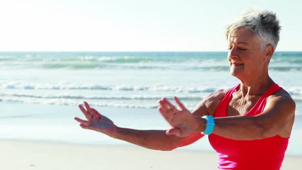 Senior woman doing exercise on beach