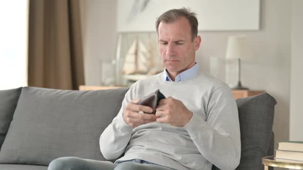 Worried Middle Aged Man Checking Empty Pocket for Money