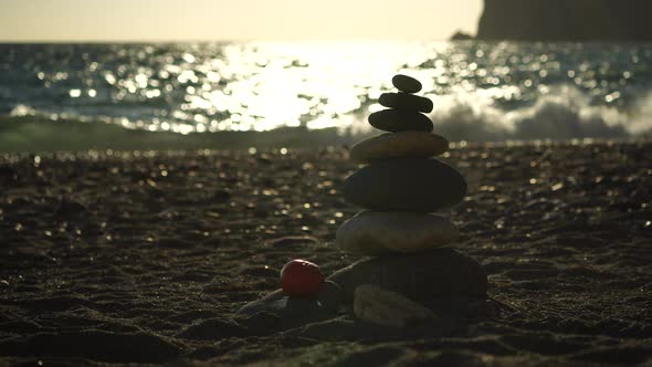 Balanced Pebbles Pyramid on the Beach on Sunny Day and Clear Sky at Sunset