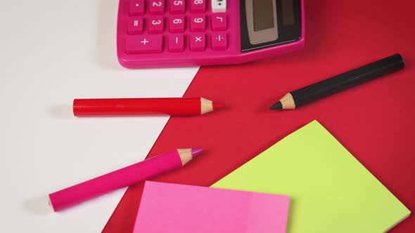 White Paper and Calculator and Crayons on a Red Desk