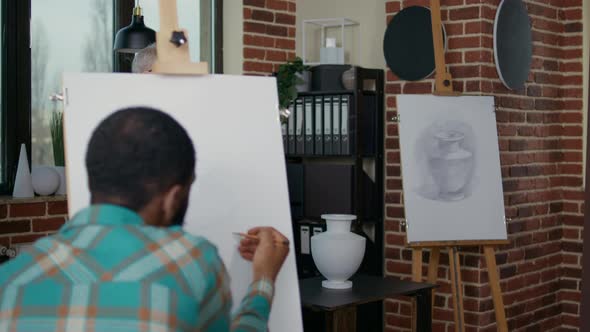 Senior Man Teaching People in Art Class to Draw on Canvas