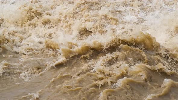 Dirty river with muddy yellow water in flooding period during heavy rains in spring.