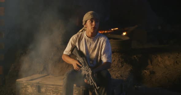 Teenager with Rifle Sitting in Trench