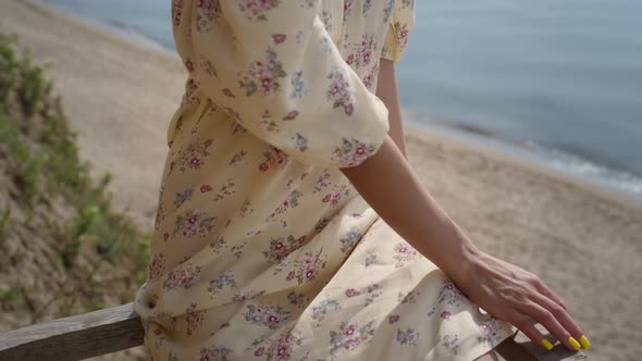 Adorable Woman Relax on Beach Wearing Flowery Dress Closeup