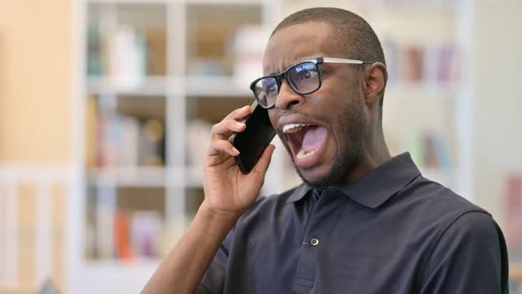 Portrait of Angry Young African Man Arguing on Smartphone