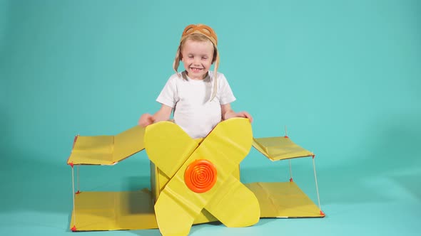 Pilot Boy with Cardboard Plane Isolated Over Blue Background.