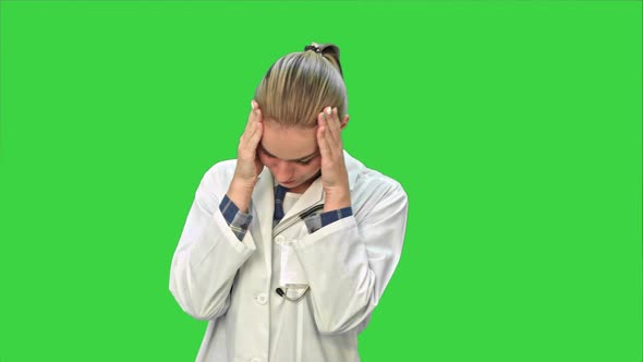 Young Female Doctor Tired, Yawning and Suffering From Headache on a Green Screen, Chroma Key.