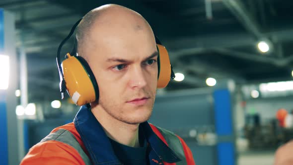 Male Operator in Safety Wear and Headphones at Work