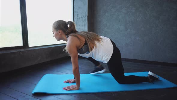 Young Woman Doing Stretching Hamstring on Yoga Mat in Fitness Club