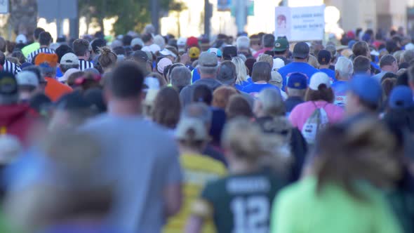 The back of a crowd of people running in a 10K race.