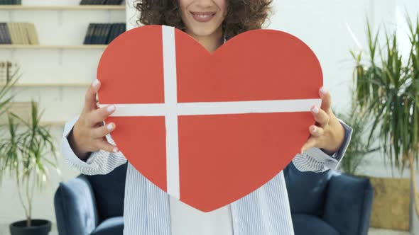 Woman Hands Holding a Big Red Gift Box in Shape of a Heart