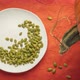 Organic raw pumpkin seeds are falling into white ceramic plate  - VideoHive Item for Sale