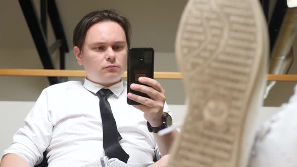 Young Man Using Smartphone at Workplace