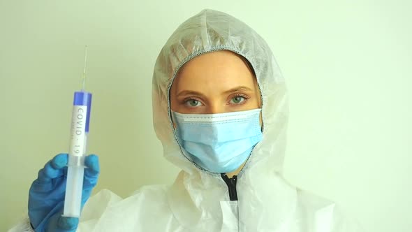 Virologist Woman in Chemical Protection Mask Glasses and Gloves Holding Potential Vaccine at the Lab