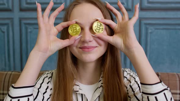 Woman Freelancer Holding Two Gold Coins at Home Successful Developer Programmer Earning Bitcoins