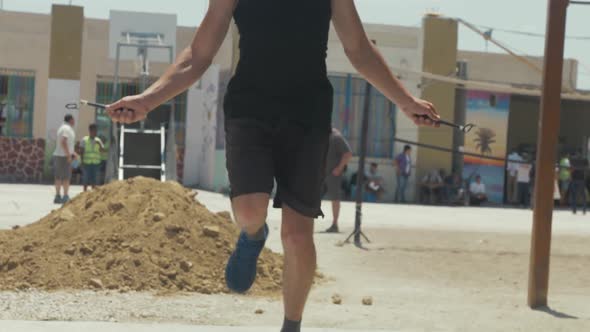 Athletic young man jumping rope outdoors running in place slow-mo