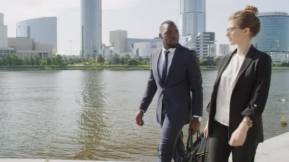 Multiethnic Business Partners Walking Along River