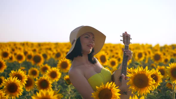 Happy Woman Sunflower Field Playing Ukulele Singing