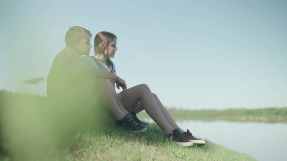 Children sitting together on hillside looking at view