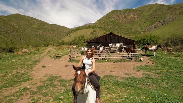 Female rider riding horse near enclosure