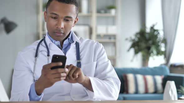 AfricanAmerican Doctor Working on Medical Documents and Laptop Paperwork