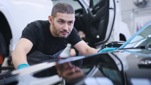 A Man Rubs the Surface of the Car After Polishing