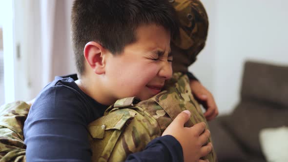 Veteran soldier greeting and hugging his son reunited after US army service - Family concept