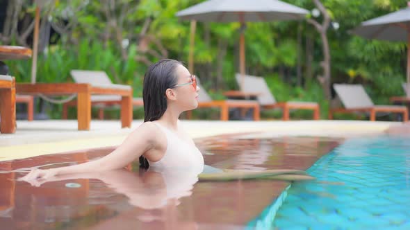 Young asian woman enjoy around outdoor swimming pool for leisure