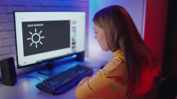 Teenager watching video at home. Young woman looking at computer at home