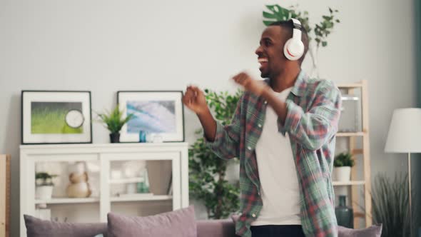 Joyful African American Student Is Dancing Singing and Listening To Music Through Wireless