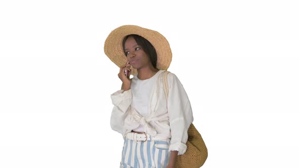 Pretty Young African American Woman in a Straw Hat Talking on Her Phone on White Background