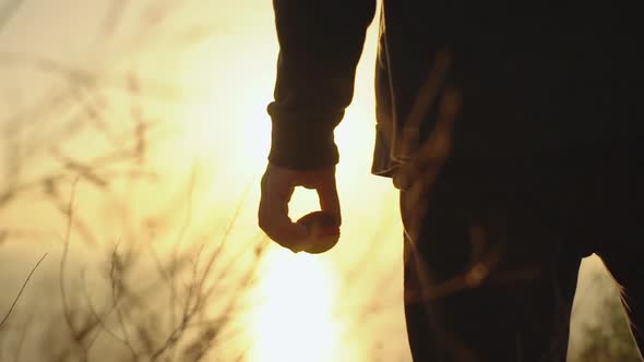 Silhouette From Back of Young Man Wearing Black Clothes Standing on the Edge of Cliff Looking Ahead