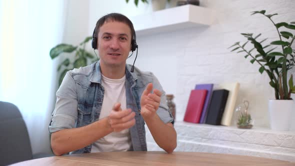 Head Shot Millennial Guy Sit in Living Room Makes Video Call Looks at Camera Conversation Distant