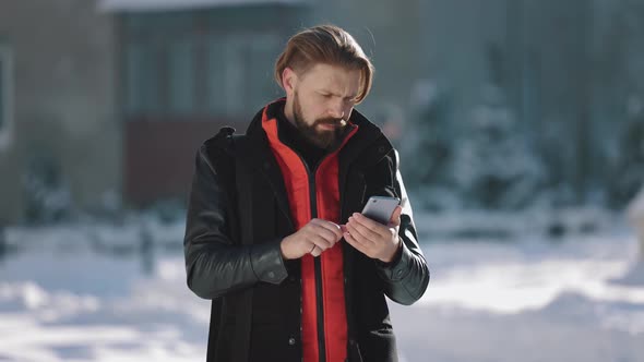 Man Typing Messages on Mobile Outdoors