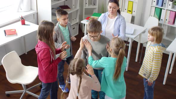 Teenager Playing Trust Building Game with Other Kids and Psychologist