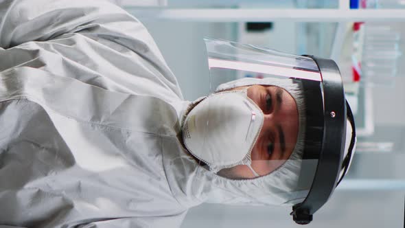 Vertical Video Doctor in Protection Suit Looking Exhausted at Camera