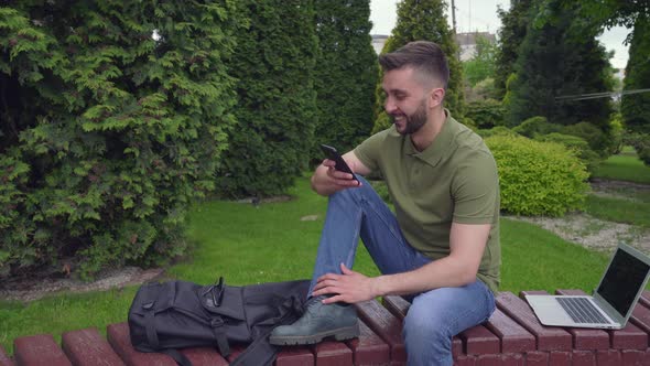 Happy Bearded Man Talking on Cell Phone in Green City Park