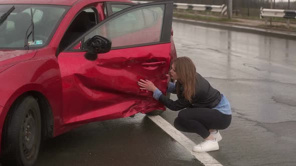 Portrait of a Frightened Girl Near Her Broken Car After a Accident on a Wet Road