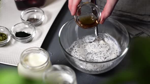 Adding maple syrup into natural yogurt with chia seeds