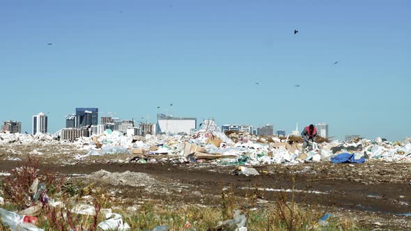 Garbage dump. Skyscrapers, construction site with crane and houses of big city