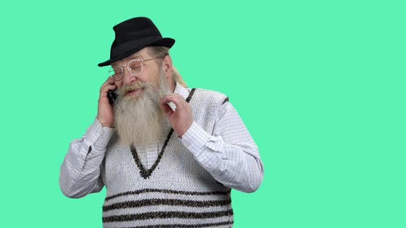 Senior Man Talking on Phone on Color Background